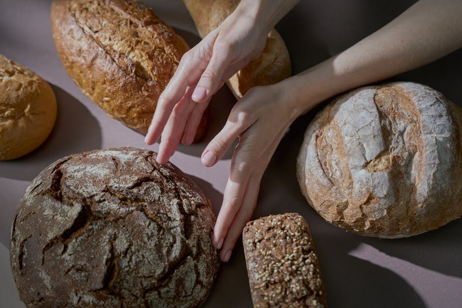 Händer som vidrör nybakat bröd i varmt ljus