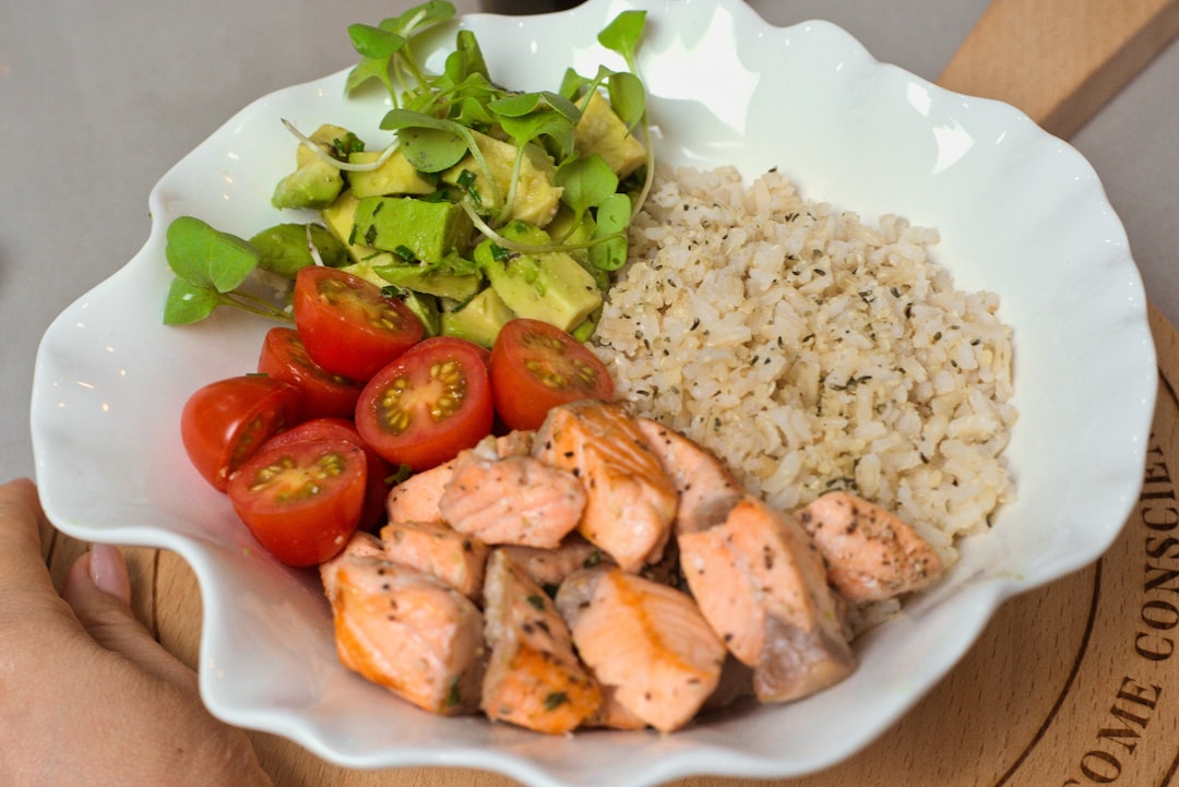 proteinrik måltid med kyckling, ris, tomater och avokado i vit skål