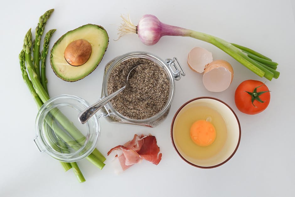 Näringsrik sammansättning med ägg, avokado, sparris och tomater på vit bakgrund