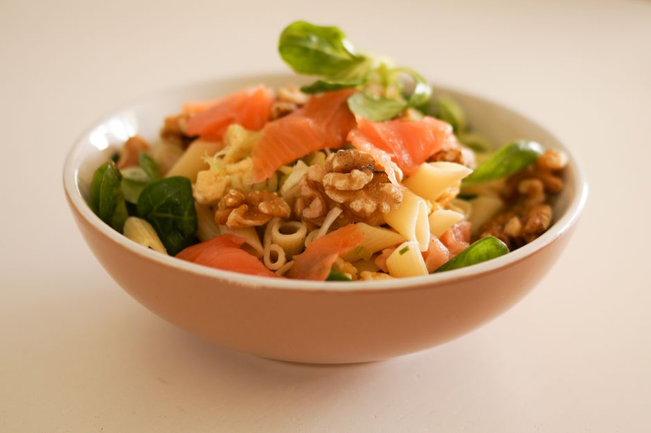 Pastasallad med rökt lax, valnötter och grönsaker i keramikskål