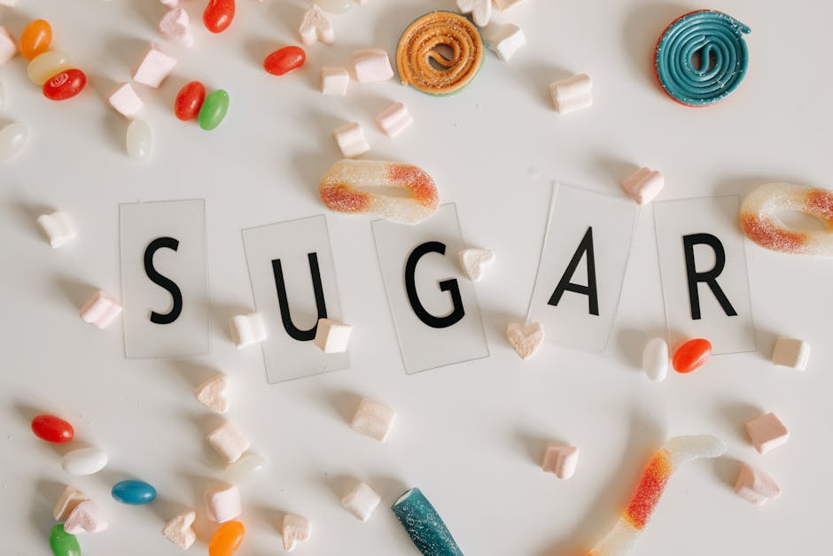 Färgglada godis och sötsaker arrangerade runt ordet 'SUGAR' på vit bakgrund