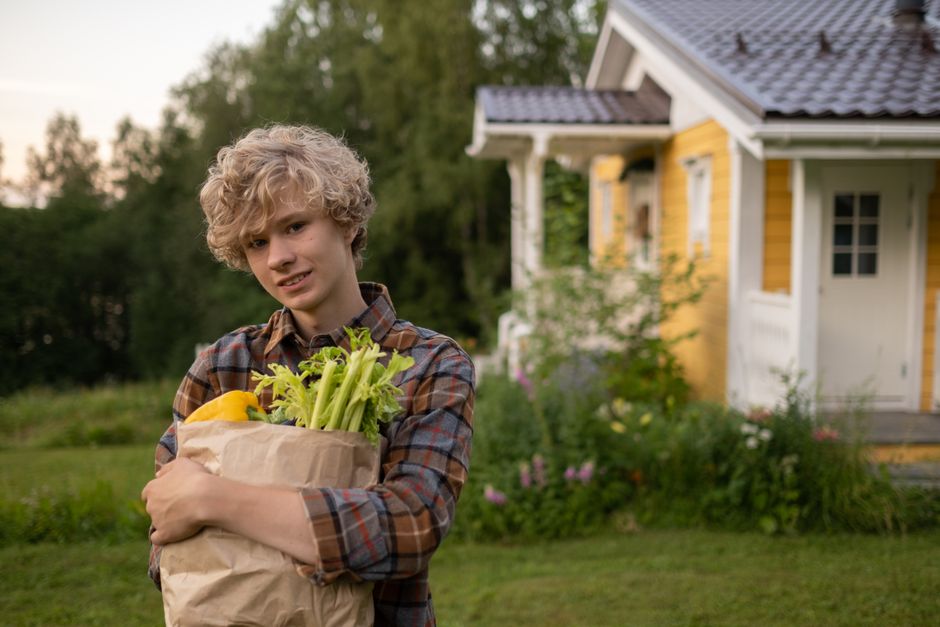 Tonåring håller matkasse med färska grönsaker