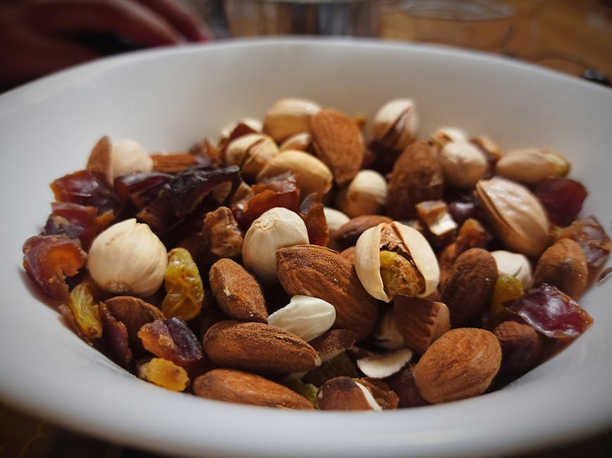 Närbild av blandade nötter och torkad frukt i en vit skål