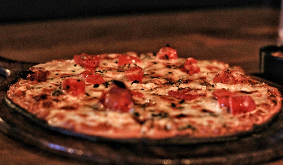 A pizza sitting on top of a pan on a table